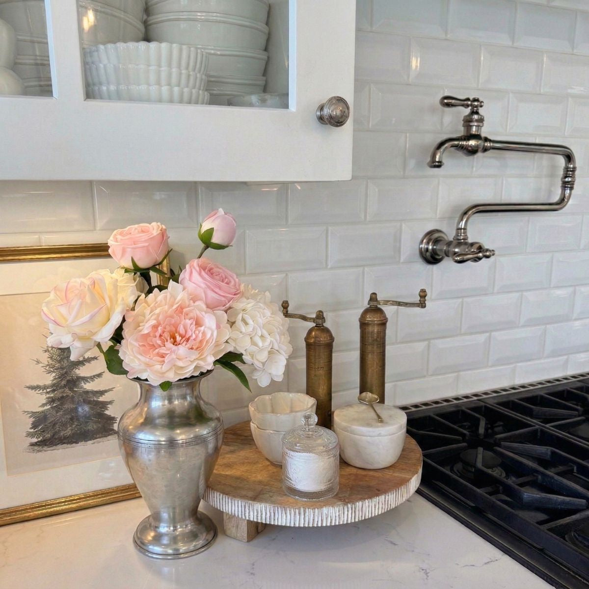 Decorative kitchen setup with realistic artificial flowers, candles, and a wooden tray on a countertop. For My Faux Florist Canada.