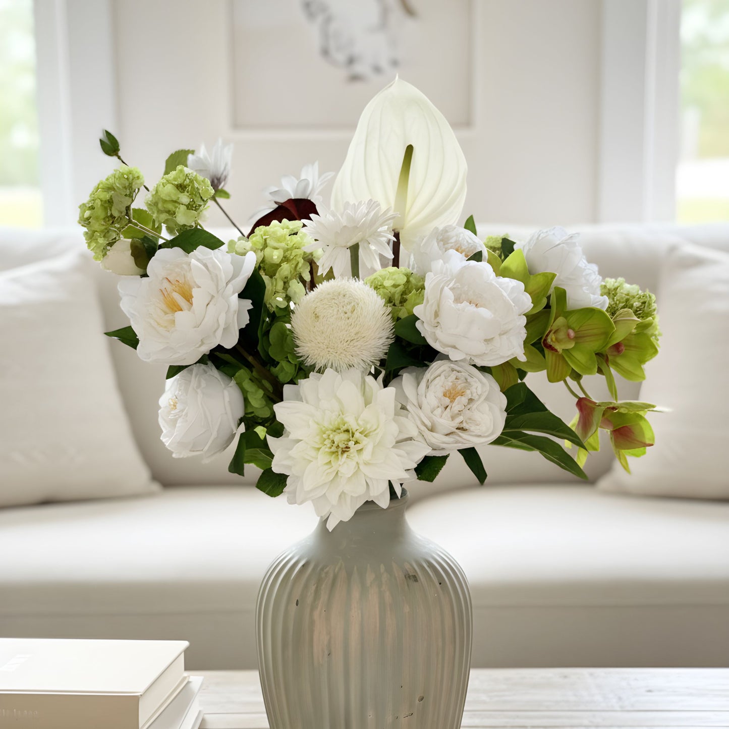 Floral arrangement of realistic faux flowers in a vase on a coffee table with a blurred background.  Faux peonies, faux roses, faux hydrangea, and faux orchids in an artificial flower bouquet for My Faux Florist Canada.