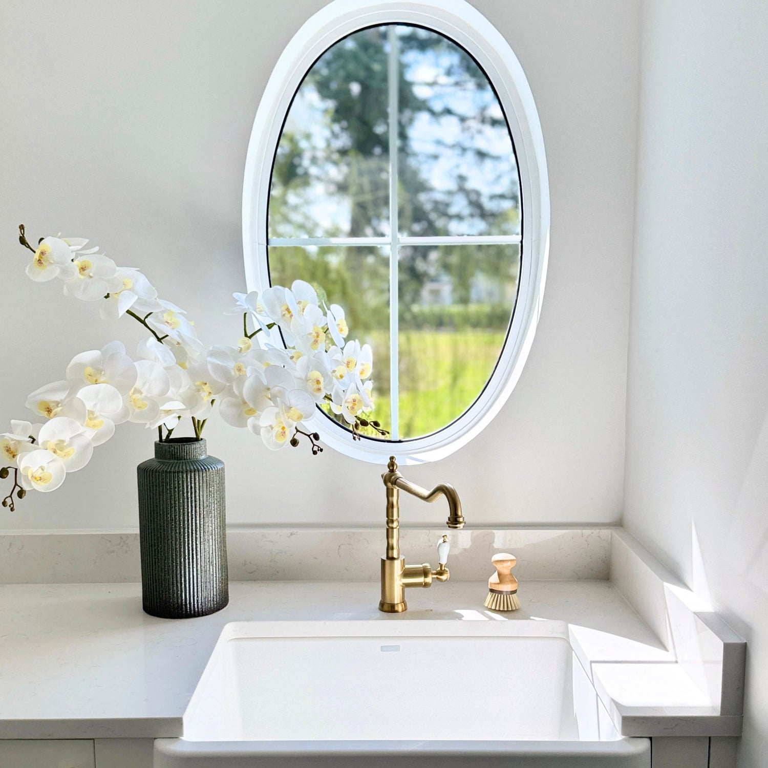Bathroom sink with gold faucet, round mirror, and white artificial orchids - for My Faux Florist Canada.