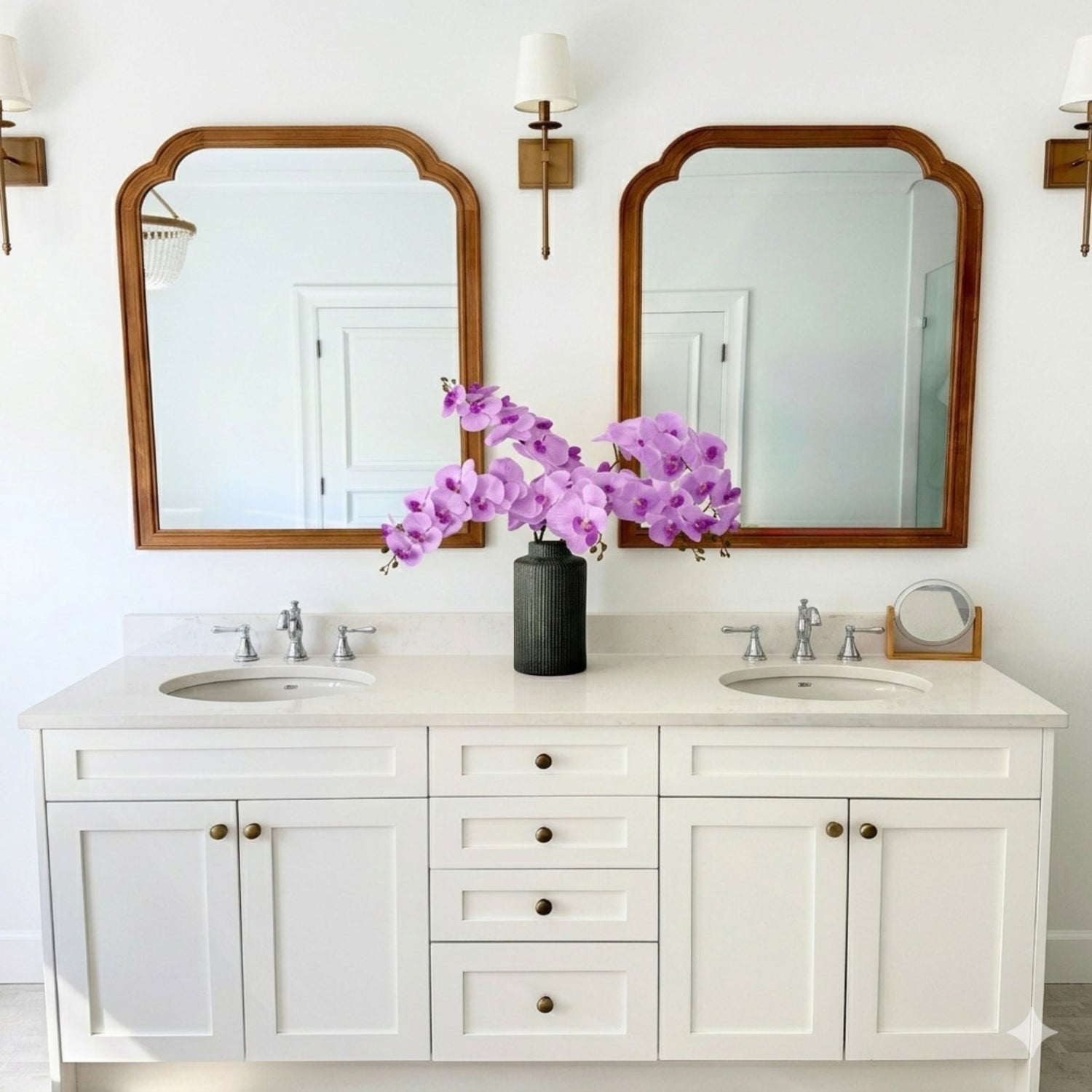 Bathroom vanity with two mirrors, a vase of purple artificial orchids, and wall sconces - for My Faux Florist Canada.