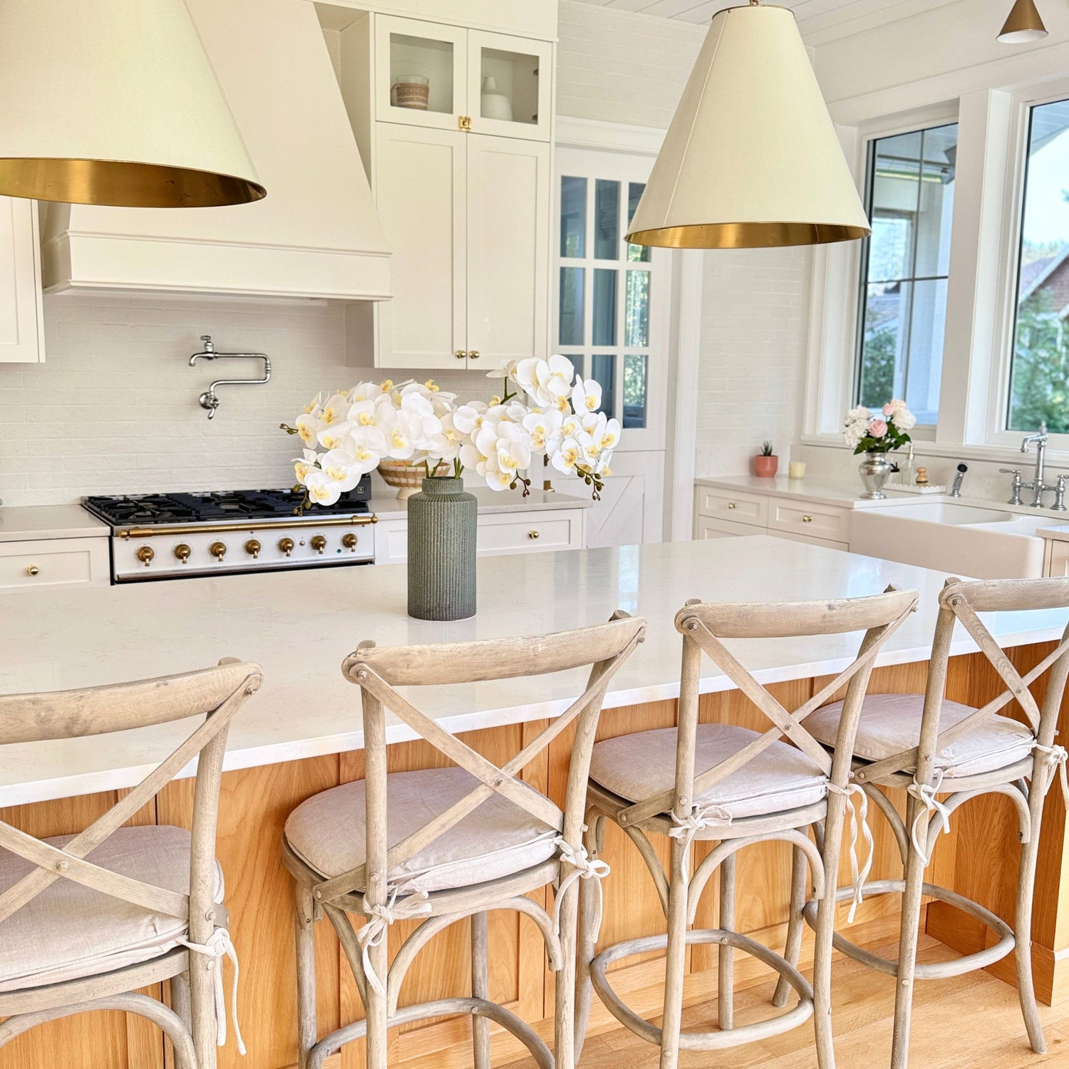 Modern kitchen with white cabinets, marble countertops, and realistic artificial orchids in white - for My Faux Florist Canada.