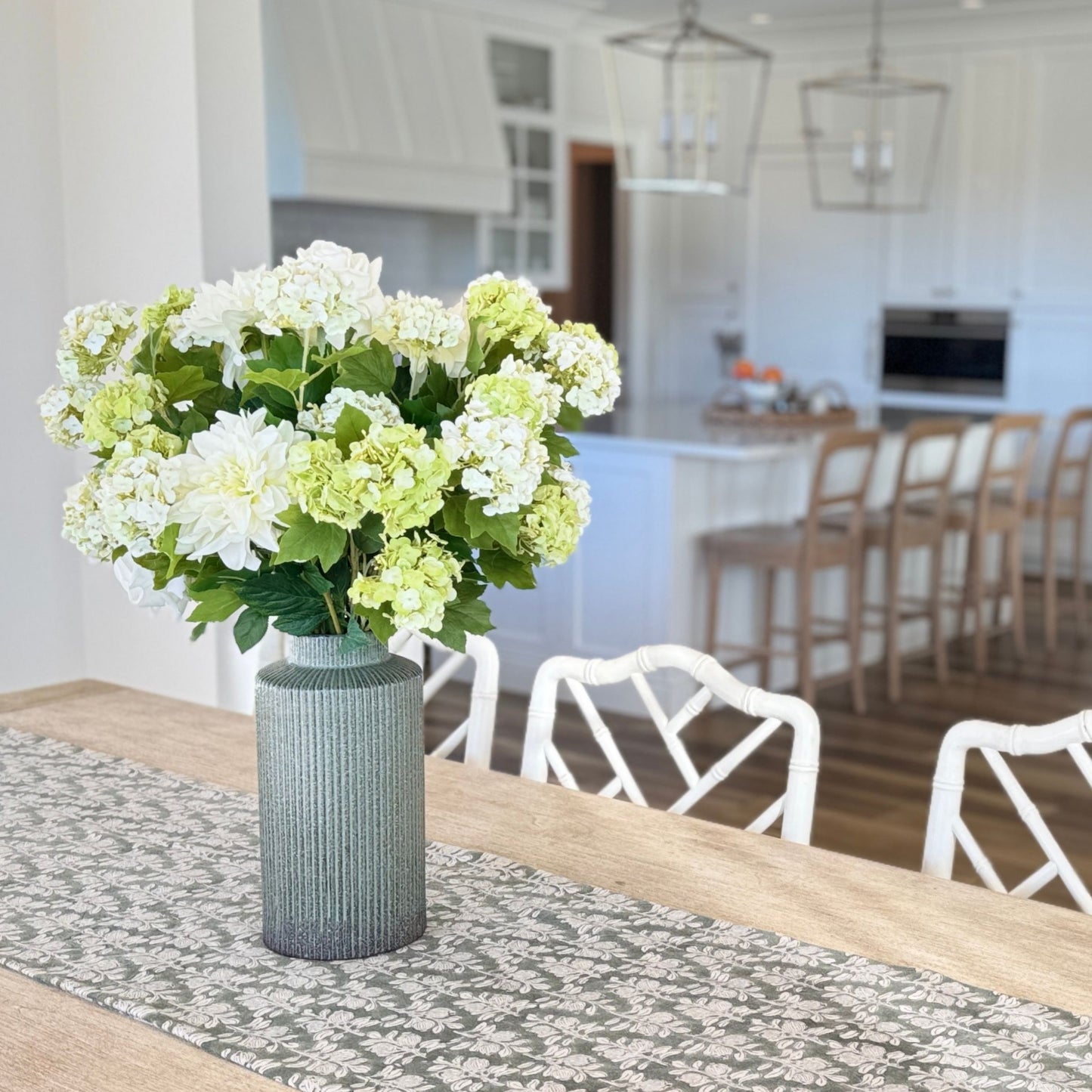 Vase with realistic artificial flowers on a dining table in a kitchen setting for My Faux Florist Canada