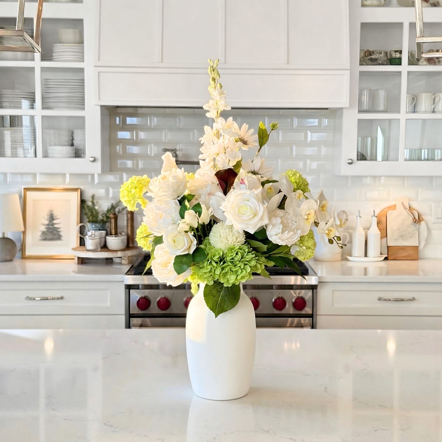 White vase with realistic artificial flowers on a kitchen counter. Faux peonies, faux roses, faux hydrangea, and faux orchids in an artificial flower bouquet for My Faux Florist Canada.