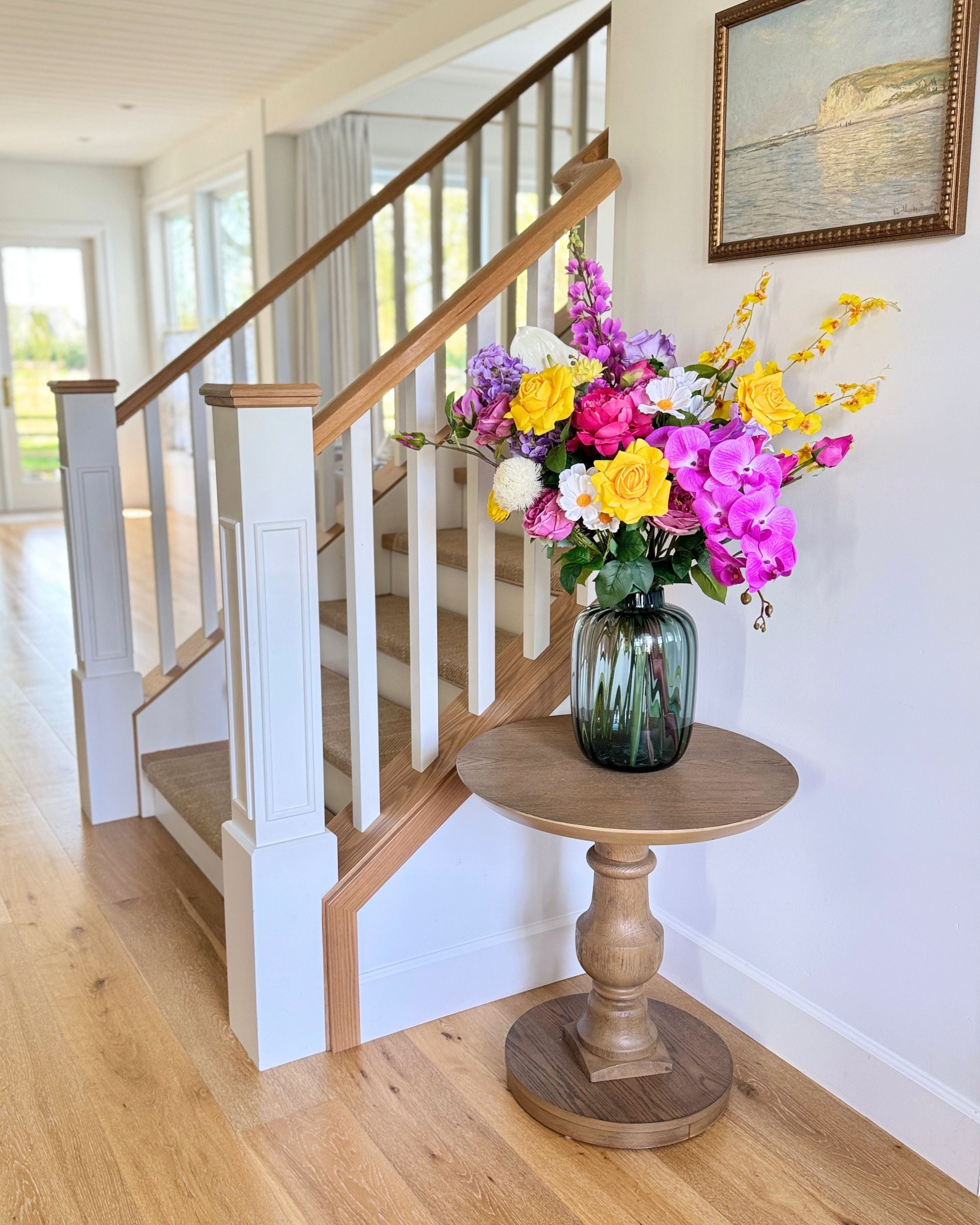 Colorful bouquet of realistic artificial flowers in a vase on a wooden side table in a home setting. Faux peonies, faux roses, faux hydrangea, and faux orchids in an artificial flower bouquet for My Faux Florist Canada.