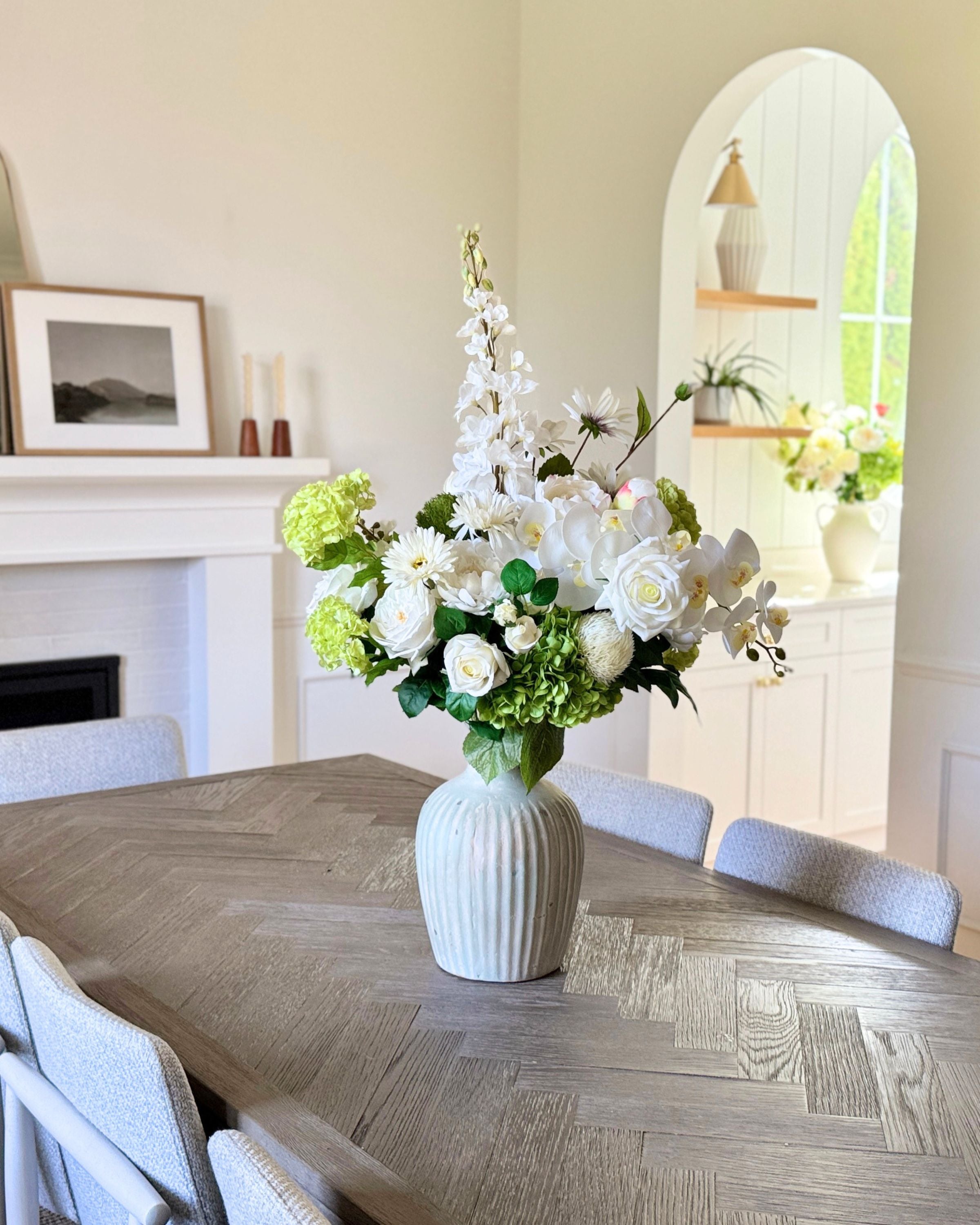 Dining room with a vase of white and green realistic artificial flowers on a table. Faux peonies, faux roses, faux hydrangea, and faux orchids in an artificial flower bouquet for My Faux Florist Canada.