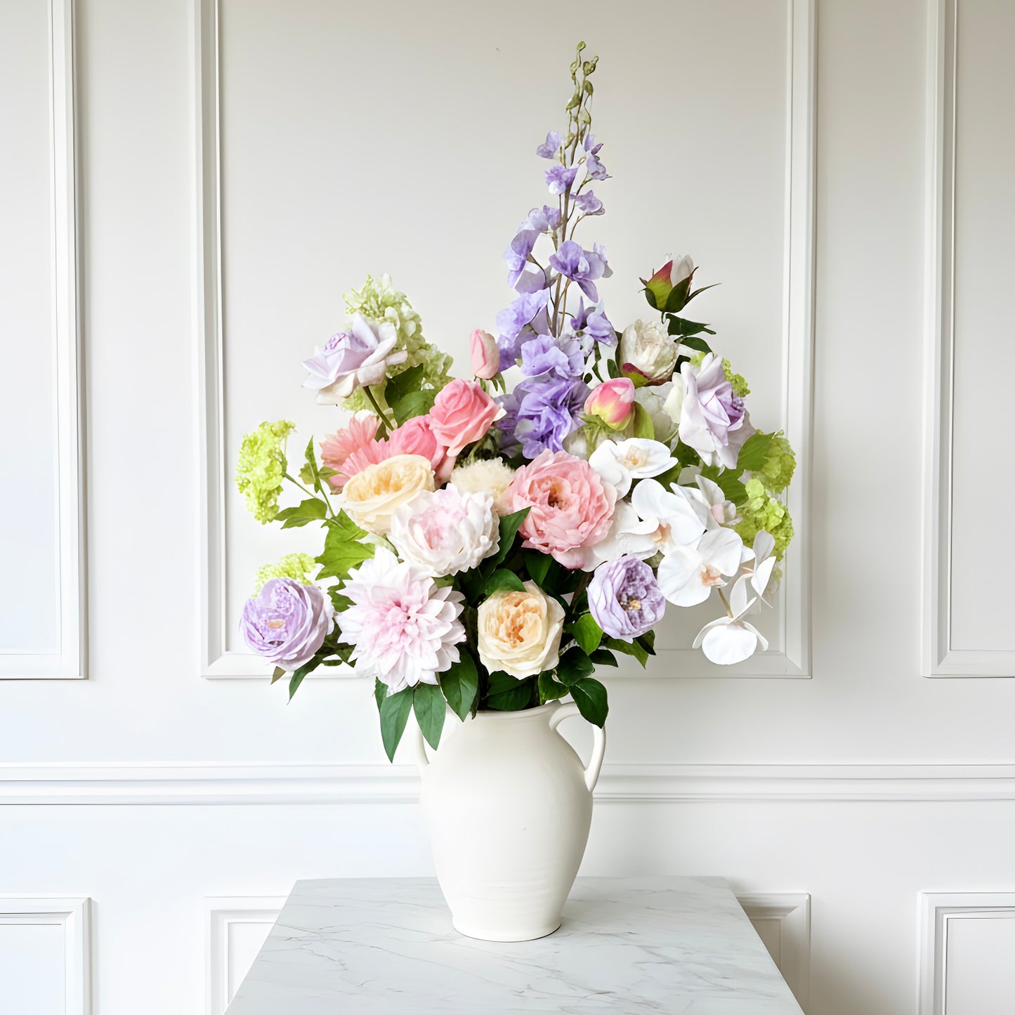 Bouquet of pastel realistic artificial flowers in a white vase against a white wall. Faux peonies, faux roses, faux hydrangea, and faux orchids in an artificial flower bouquet for My Faux Florist Canada.