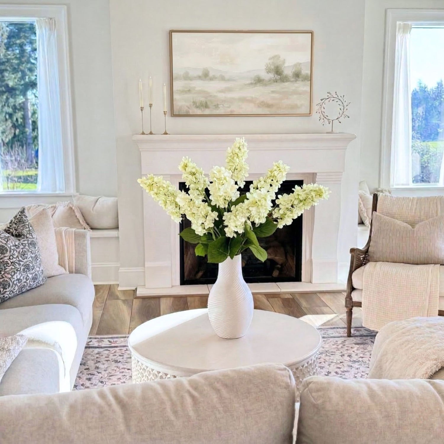 Living room with a vase of realistic artificial flowers on a coffee table in front of a fireplace that are artificial hydrangeas for My Faux Florist Canada.