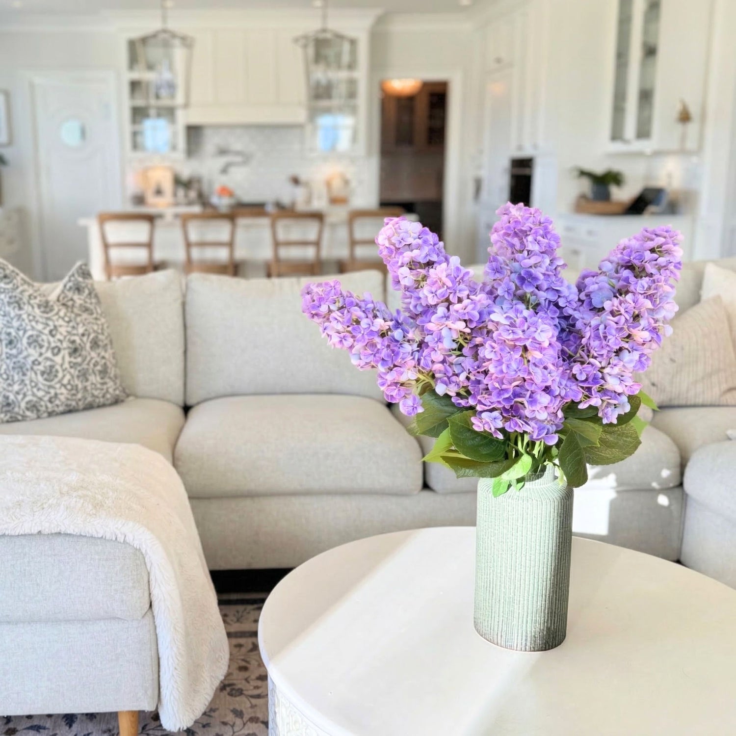 Purple artificial hydrangea flowers in a vase on a coffee table in a living room. realistic artificial flowers canada for My Faux Florist Canada