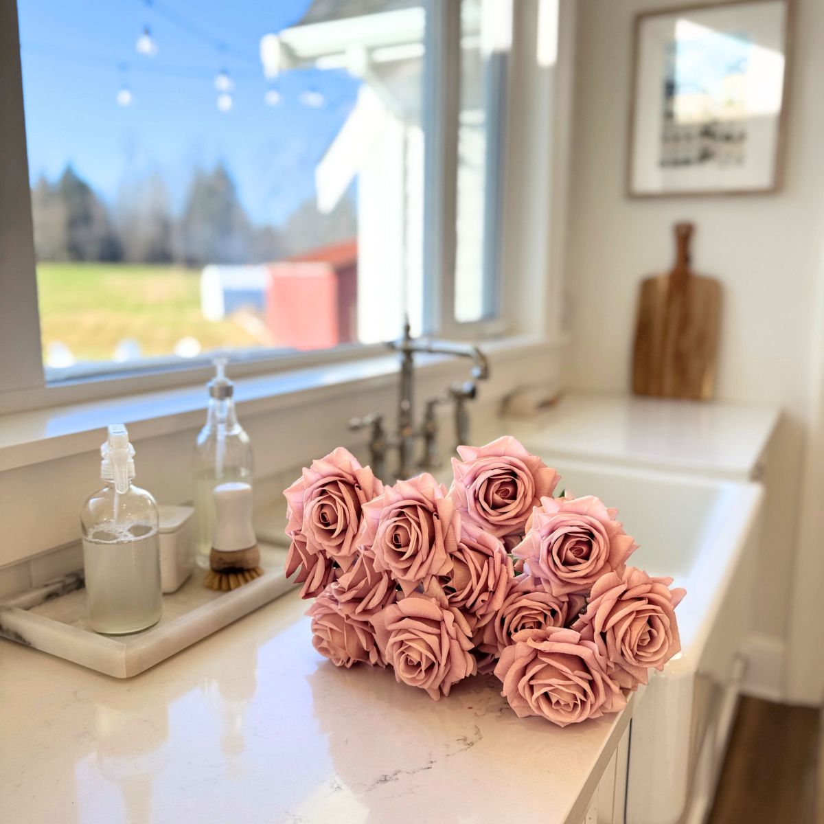 Bouquet of pink realistic artificial roses on a kitchen counter with a window in the background - for My Faux Florist Canada.