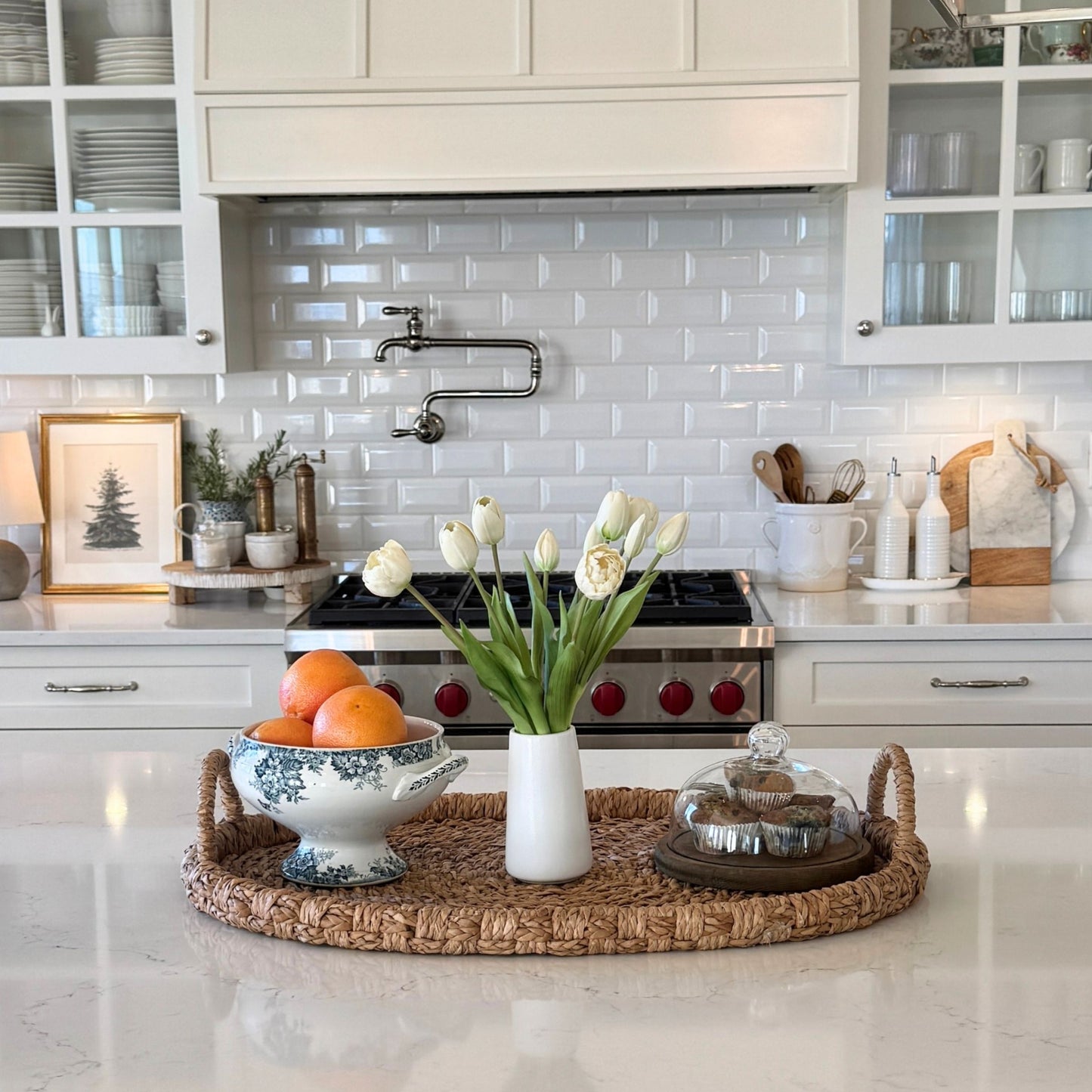 Modern kitchen with white cabinets, marble countertop, decorative elements, including a vase of artificial tulips for My Faux Florist Canada.