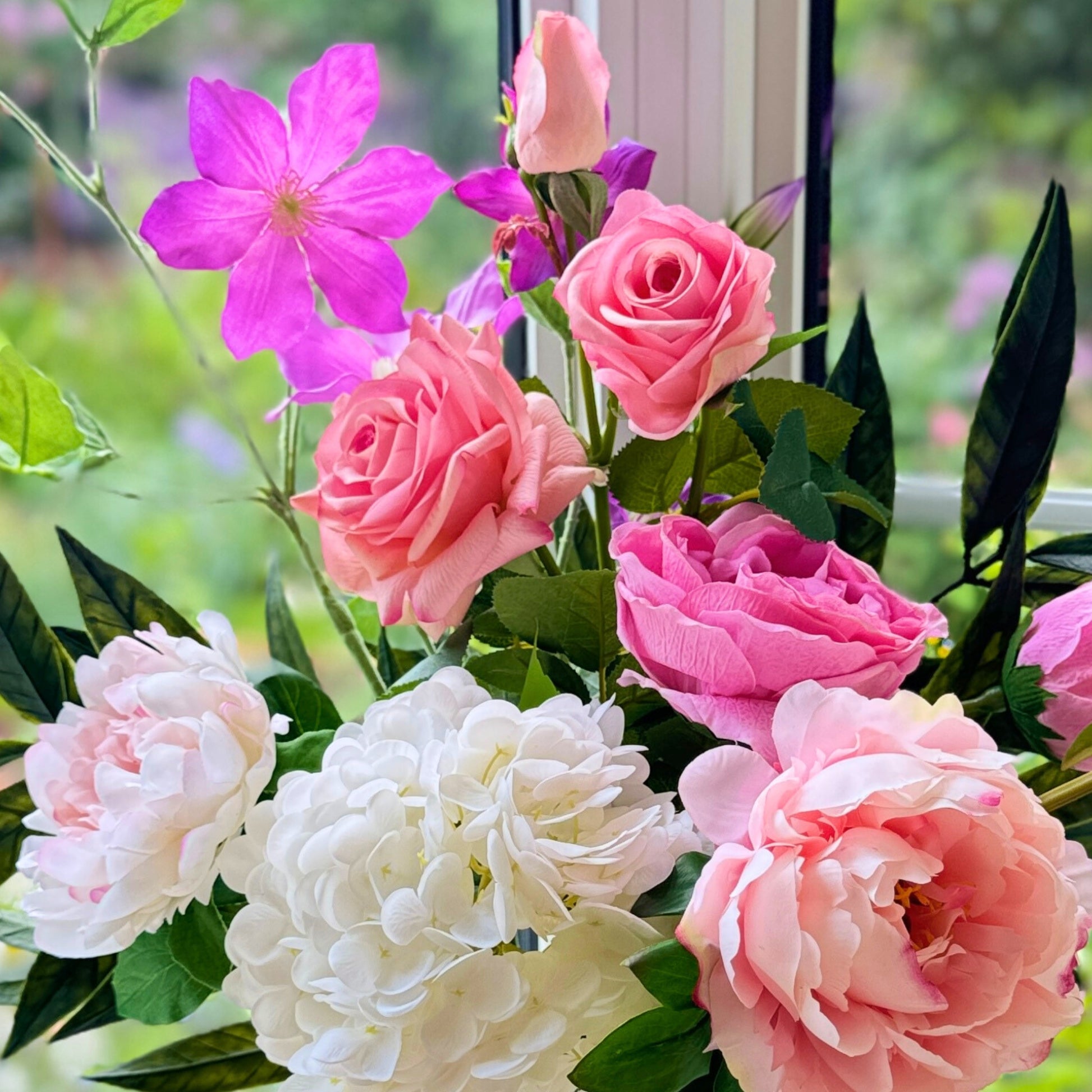 Closeup of a Bouquet of brightly coloured artificial flowers and Real Touch flowers in a window, by My Faux Florist artificial flowers Canada.