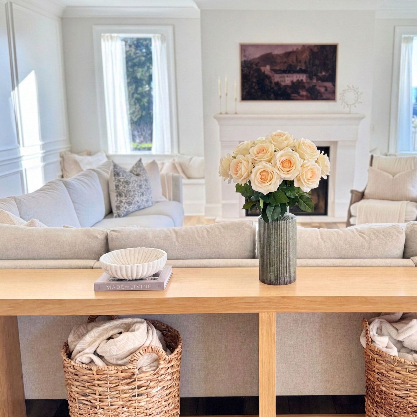 Living room with a sofa, coffee table, and decorative elements. Large vase of creamy realistic artificial flowers from My Faux Florist Canada