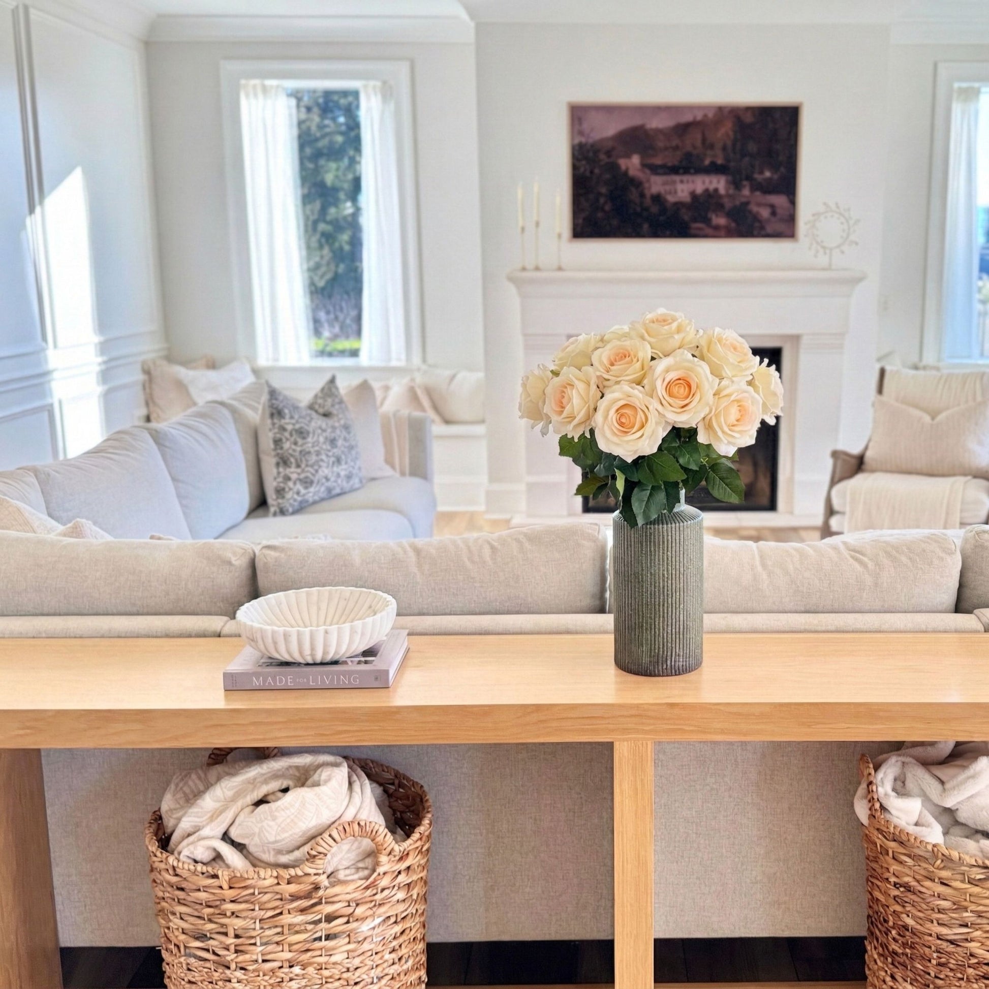 Living room with a sofa, coffee table, and decorative elements. Large vase of creamy realistic artificial flowers from My Faux Florist Canada