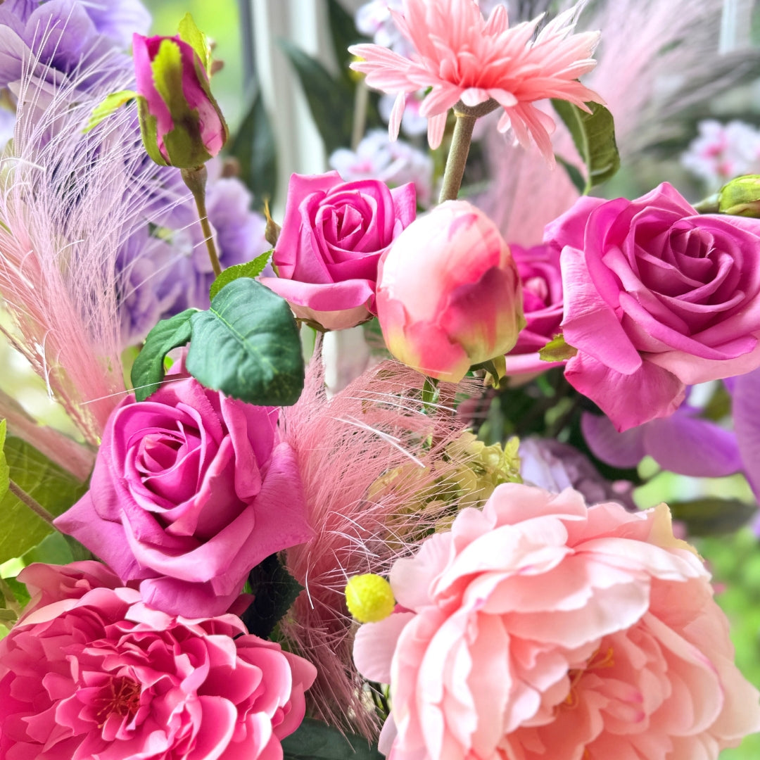 Close up of a bouquet of brightly coloured artificial flowers and Real Touch flowers in a window, by My Faux Florist artificial flowers Canada.
