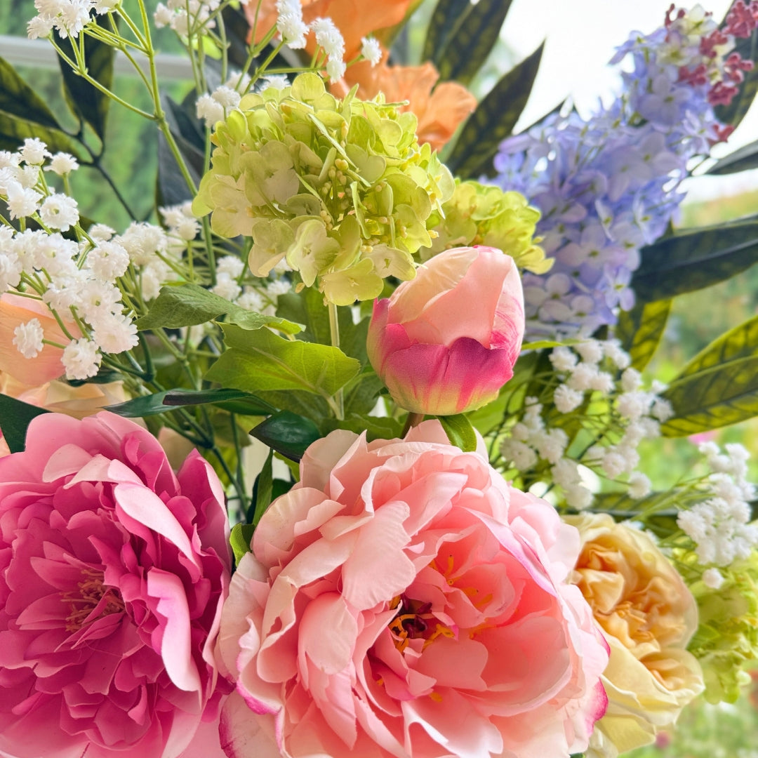 Close up of a Bouquet of brightly coloured artificial flowers and Real Touch flowers in a window, by My Faux Florist artificial flowers Canada.