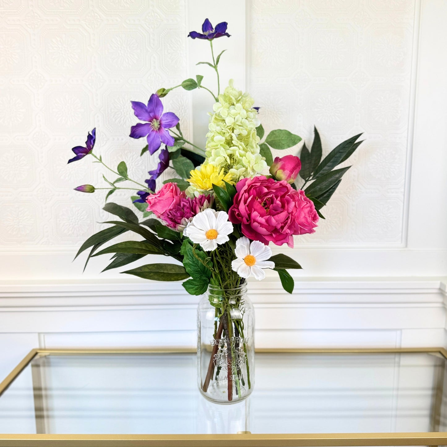 Bouquet of brightly coloured artificial flowers and Real Touch flowers in front of a white wall, by My Faux Florist artificial flowers Canada.